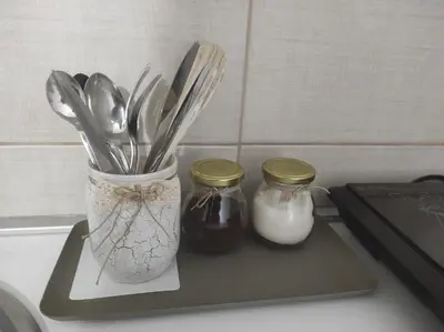 two jars of utensils sitting on a cutting board at HostelChe Guest House in Smederevo