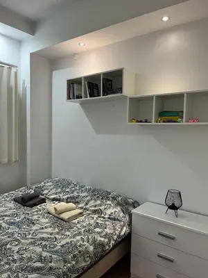 a bedroom with a bed and a dresser and shelves at Studio apartment near the city center in Belgrade
