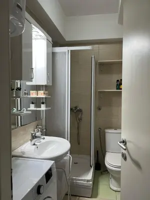 a white bathroom with a sink and a toilet at Studio apartment near the city center in Belgrade