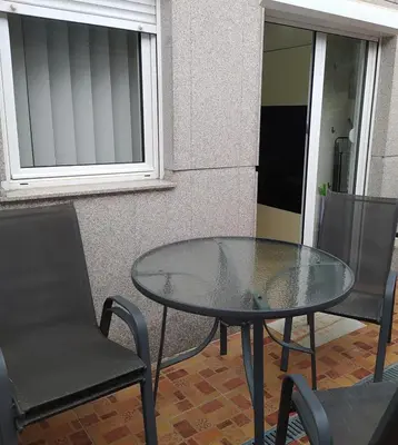 a glass table and two chairs on a patio at Studio apartment near the city center in Belgrade
