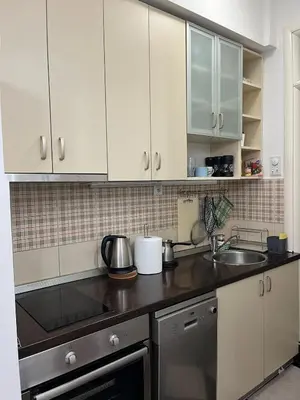 a kitchen with white cabinets and a sink at Studio apartment near the city center in Belgrade