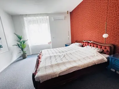 a bedroom with a bed and a red wall at Downtown Buzz Mili in Belgrade
