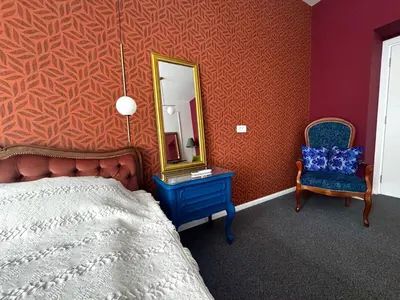 a bedroom with a bed and a mirror and a chair at Downtown Buzz Mili in Belgrade