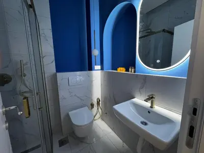a bathroom with a sink and a toilet and a mirror at Downtown Buzz Mili in Belgrade