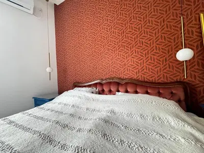 a bedroom with a bed with a red wall at Downtown Buzz Mili in Belgrade