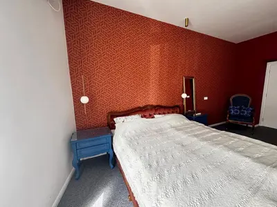a bedroom with a bed and a red wall at Downtown Buzz Mili in Belgrade