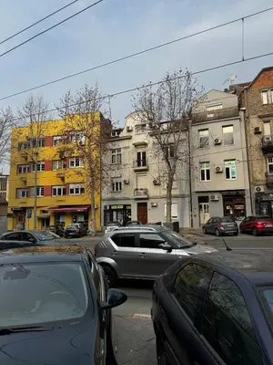 a parking lot with cars parked in front of buildings at Downtown Buzz Mili in Belgrade
