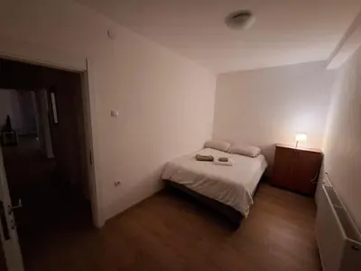 a small bedroom with a bed and a night stand at Apartman Palma in Belgrade