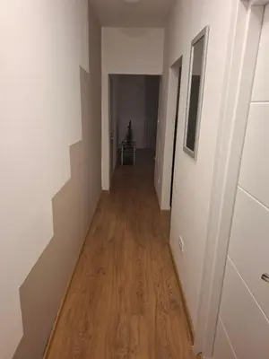 a hallway with white walls and a wooden floor at Apartman Palma in Belgrade