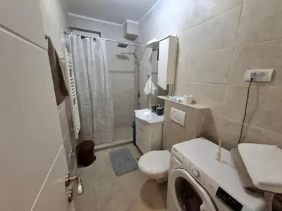 a bathroom with a toilet and a washing machine at Apartman Palma in Belgrade