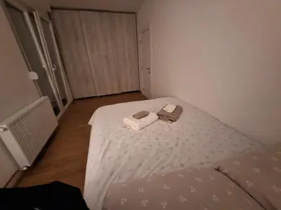 a small room with a bed with a towel and a book at Apartman Palma in Belgrade