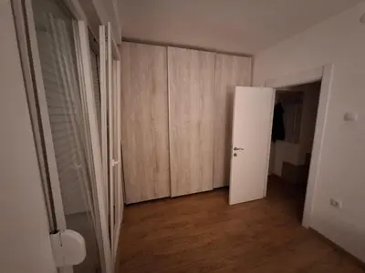 an empty room with a white door and wooden cabinets at Apartman Palma in Belgrade