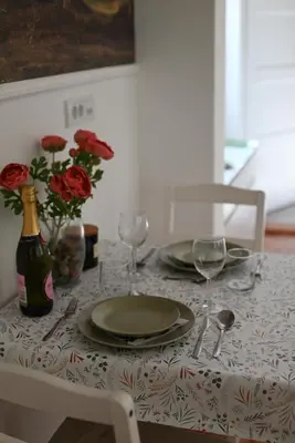 a table with plates and glasses and a bottle of wine at La Pastorela in Belgrade