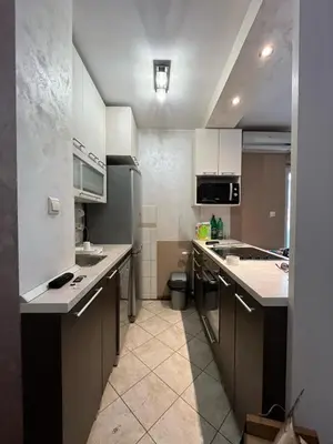 a small kitchen with white cabinets and a sink at Apartman Miladinović in Belgrade