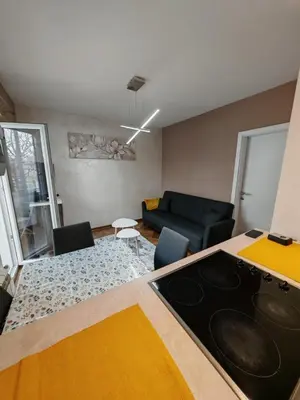 a kitchen and living room with a stove top oven at Apartman Miladinović in Belgrade
