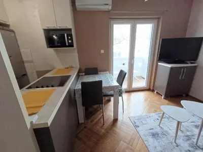 a kitchen with a counter and a table with chairs at Apartman Miladinović in Belgrade