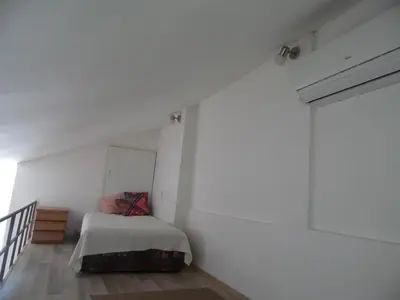 a bedroom with a bed and a white wall at Apartment Angie in Belgrade