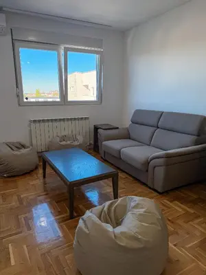 a living room with a couch and a table at Limpio Apartman in Belgrade
