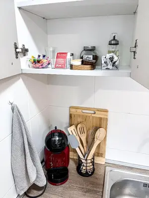 a kitchen counter with wooden utensils on a shelf at Limpio Apartman in Belgrade