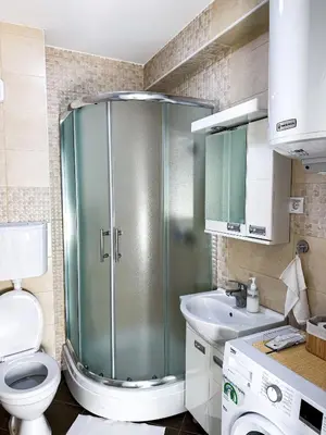 a bathroom with a shower and a toilet and a sink at Limpio Apartman in Belgrade