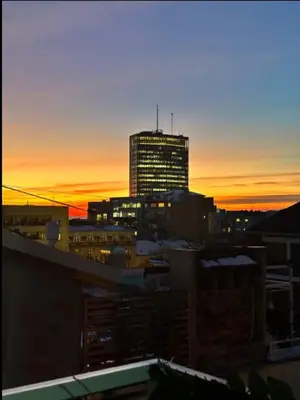a city skyline at sunset with a tall building at Huge Apartment 100sqm in Belgrade