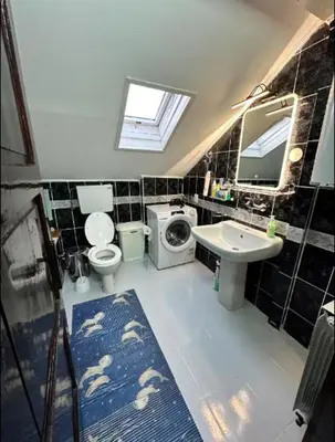 a bathroom with a toilet sink and a washing machine at Huge Apartment 100sqm in Belgrade