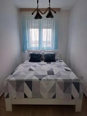 a large bed in a room with a large window at Stan na dan Ub in Ub