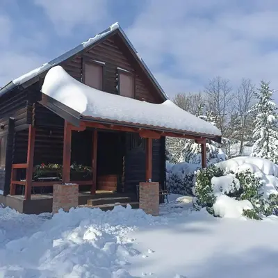 a log cabin with snow on the roof at Ranch V8 Kosmaj in Rogača