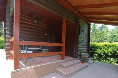 a porch of a cabin with a table and a bench at Ranch V8 Kosmaj in Rogača