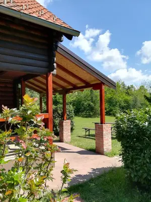 a wooden pavilion with a bench in a park at Ranch V8 Kosmaj in Rogača
