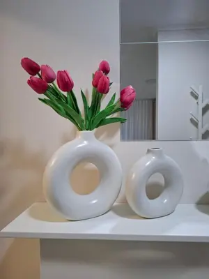 two white vases sitting on a shelf with pink tulips at Apartment Leona in Inđija