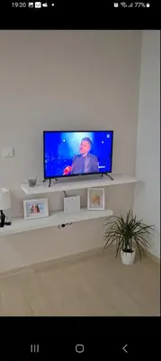 a flat screen tv sitting on a shelf in a living room at Apartment Leona in Inđija