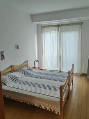 a bedroom with a bed with a blue and white striped blanket at City center Dorcol free parking in Belgrade