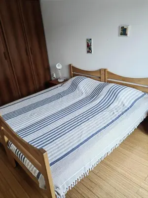 a bed with a blue and white striped blanket at City center Dorcol free parking in Belgrade