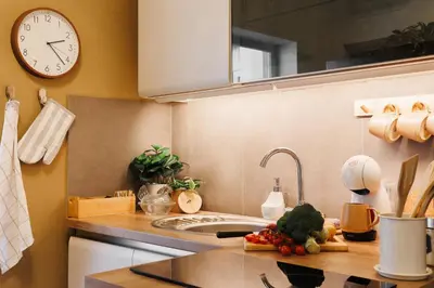 a kitchen with a sink and a clock on the wall at Creative Shelter 108m2 with Balcony Old Town in Belgrade