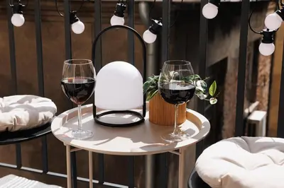 two glasses of red wine on a small table at Creative Shelter 108m2 with Balcony Old Town in Belgrade