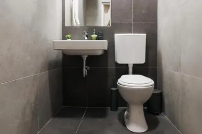 a bathroom with a white toilet and a sink at Creative Shelter 108m2 with Balcony Old Town in Belgrade