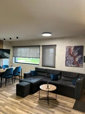 a living room with a black couch and a table at Belvedere RESORT in Smederevo