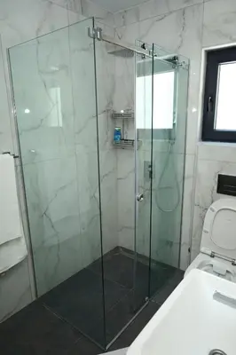 a bathroom with a glass shower with a toilet at Belvedere RESORT in Smederevo