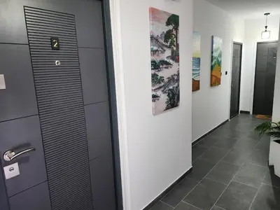 a hallway with a door and paintings on the wall at Crassula Lux 2 in Surčin