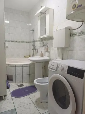 a bathroom with a toilet and a washing machine in it at Beautiful house in Smederevo