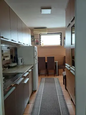 a kitchen with white cabinets and a table with chairs at Beautiful house in Smederevo
