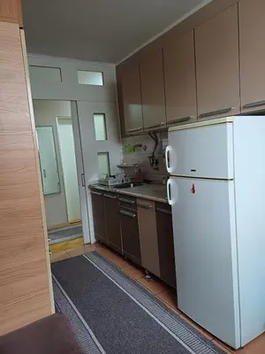 a kitchen with a white refrigerator and brown cabinets at Beautiful house in Smederevo