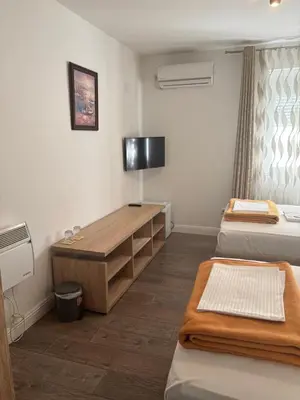 a room with two beds and a desk and a television at Apartman Popovic 2 in Ub