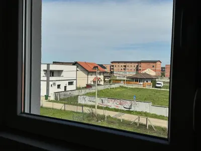 a window with a view of a field and buildings at Belgrade Airport single bed in Surčin