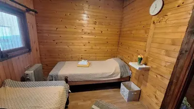 a room with two beds in a wooden cabin at Wooden house Ada in Ada Ciganlija