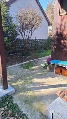 a backyard with a fence and a tree and a building at Wooden house Ada in Ada Ciganlija