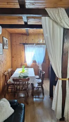 a dining room with a white table and chairs at Wooden house Ada in Ada Ciganlija