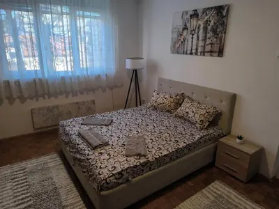 a bedroom with a bed with a lamp and pillows at R & P Apartman Mladenovac in Mladenovac