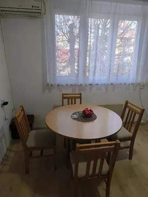 a table and chairs in a room with a window at R & P Apartman Mladenovac in Mladenovac